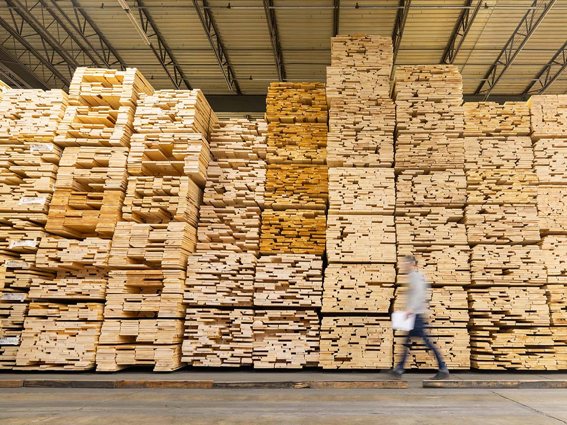 Stacks of lumber inside a window manufacturing facility used for wood window production.