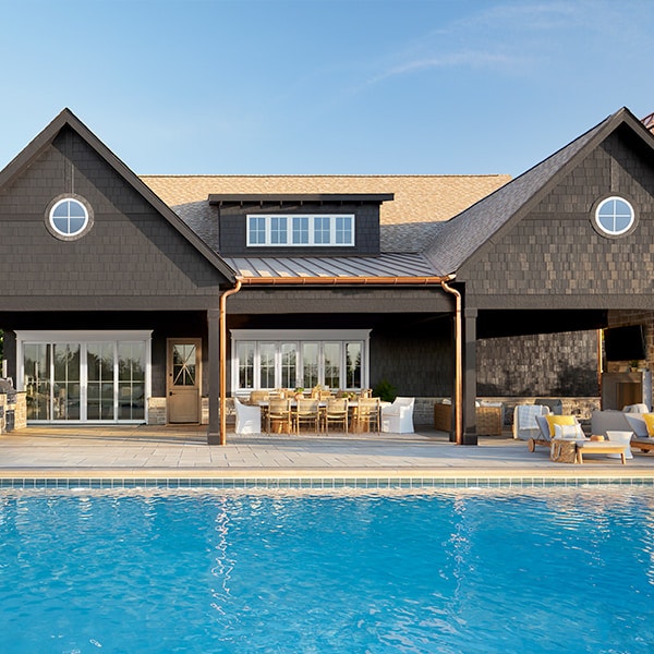 a large swimming pool in front of a contemporary home with a shed dormer