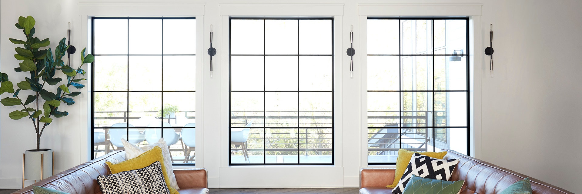 Black windows with a traditional grille pattern overlooking backyard patio.