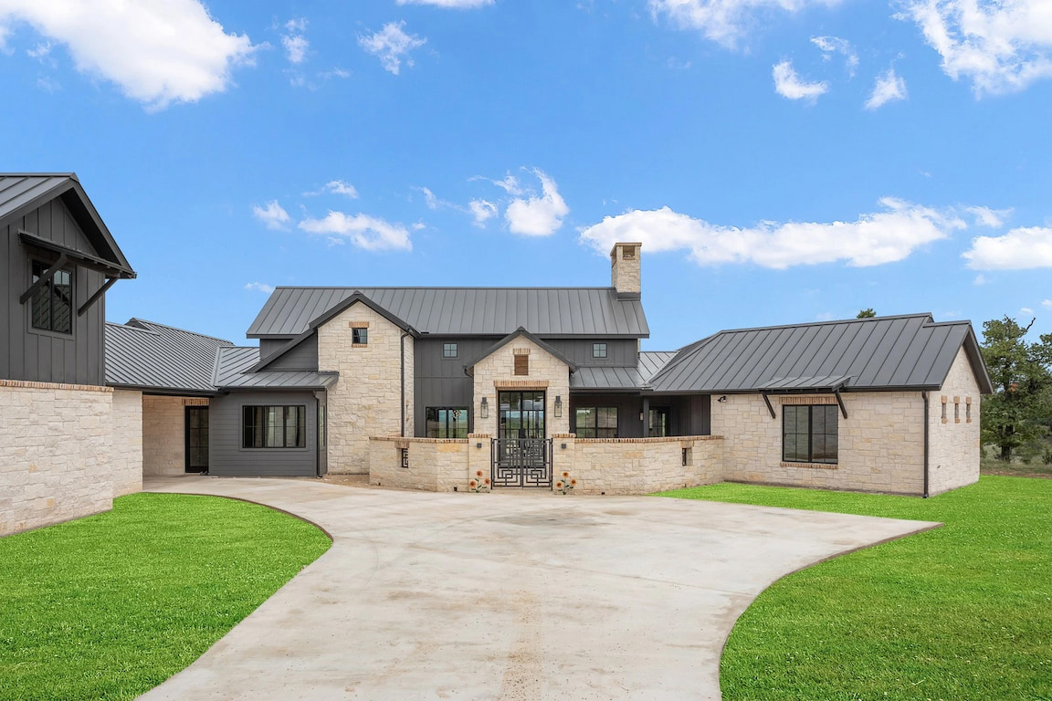 Curbside view of Texas Hill Country home with newly installed black wooden Pella windows.