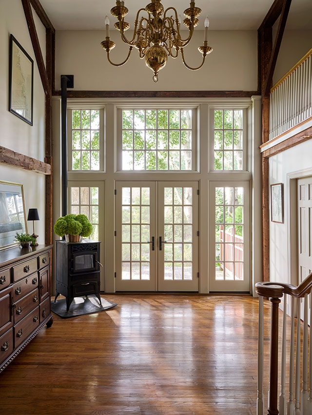 Traditional foyer with French doors and tall transom windows.