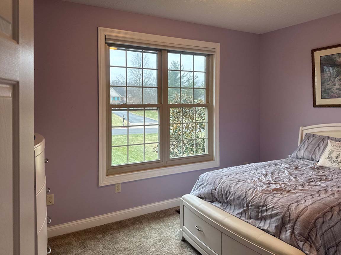 Bedroom with large window allowing natural light and outdoor views.