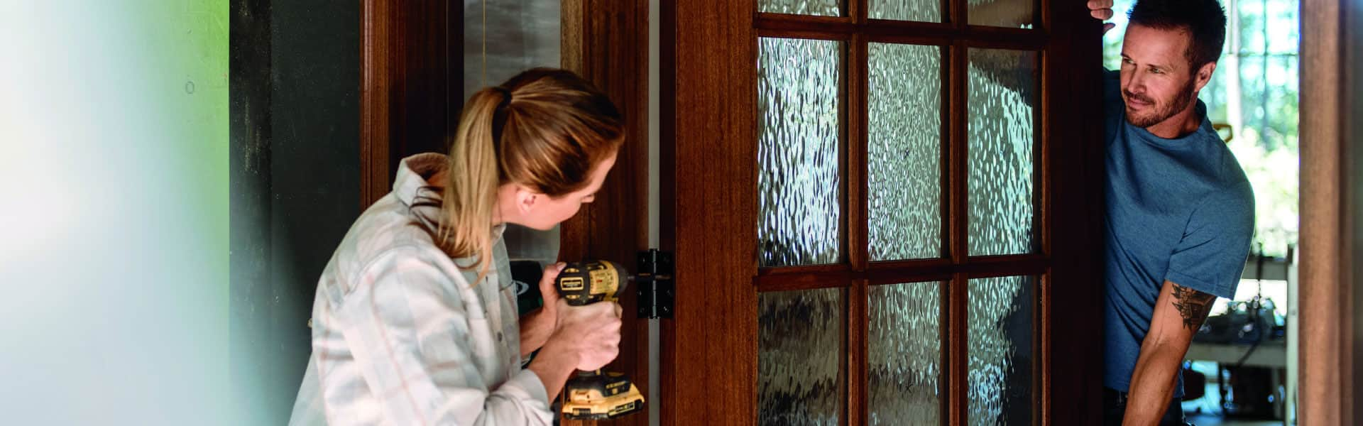 man and woman installing an entry door