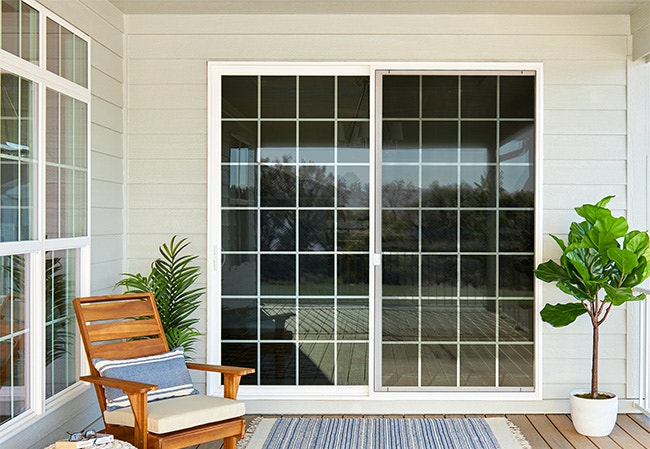 White sliding glass patio doors with traditional grille pattern on contemporary patio.