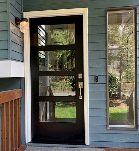 a contemporary wood front door reflects the front yard