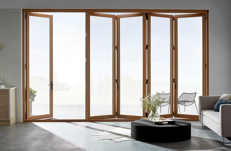 Interior view of light wood bifold doors slightly open to outside