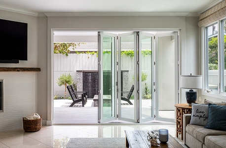 Interior view of light wood bifold doors slightly open to outside