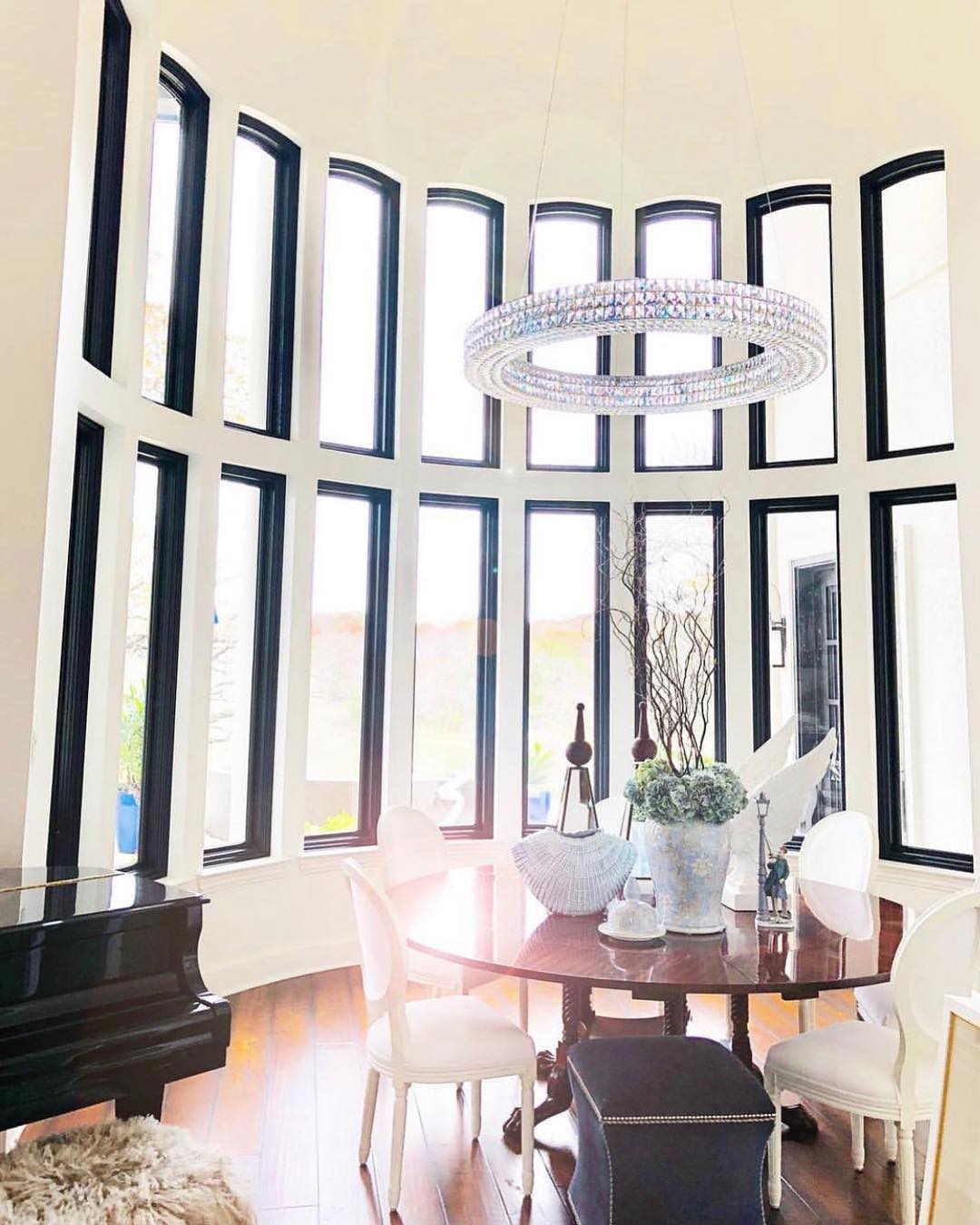 curved wall filled with black casement windows in a dining room