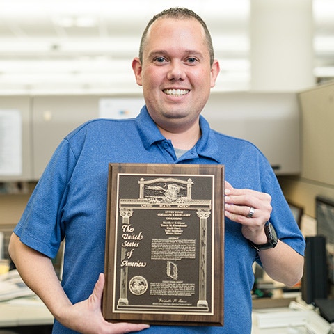 pella employee holding a patent he earned for pella
