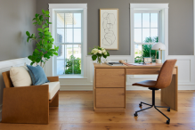Two white fiberglass windows behind a home office desk.