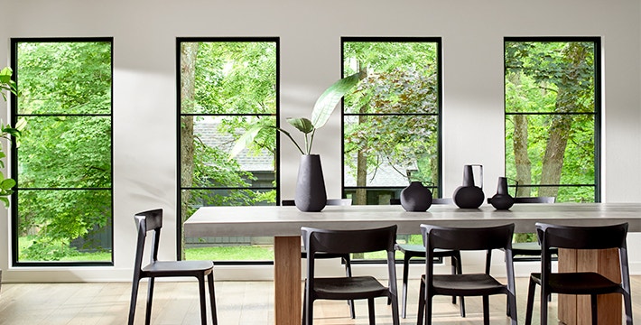 a row of floor-to-ceiling picture windows behind a contemporary table
