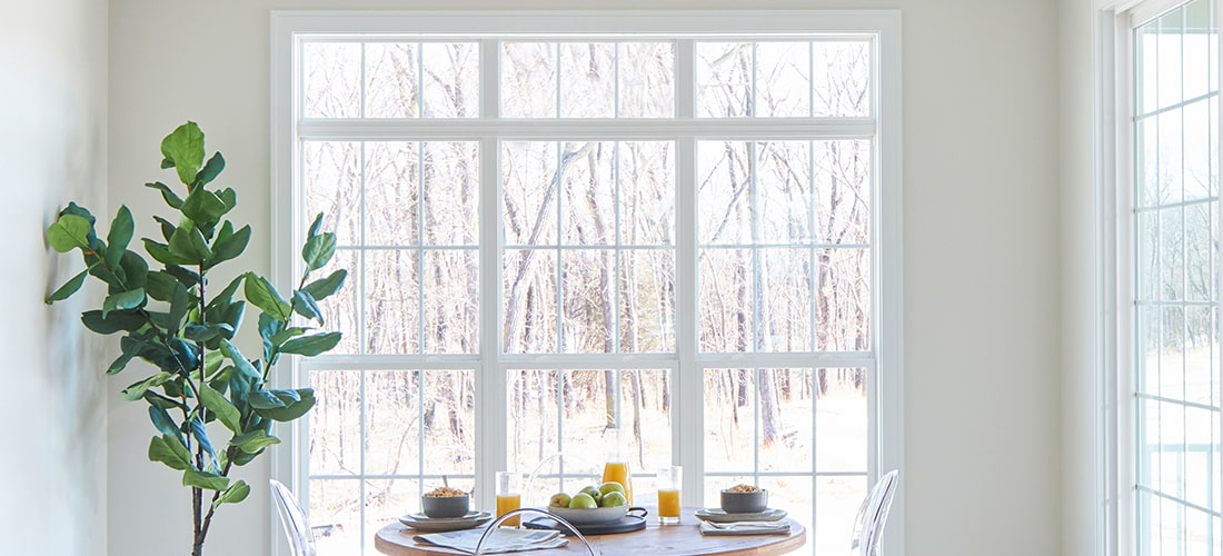 a row of floor-to-ceiling picture windows behind a contemporary table