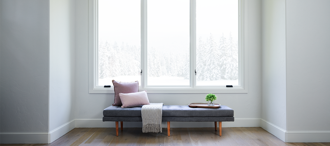 three white wood casement windows over a window seat