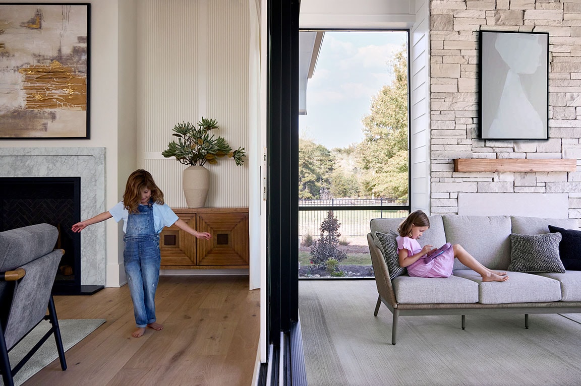 Modern indoor-outdoor living space with multislide glass doors connecting two living areas.