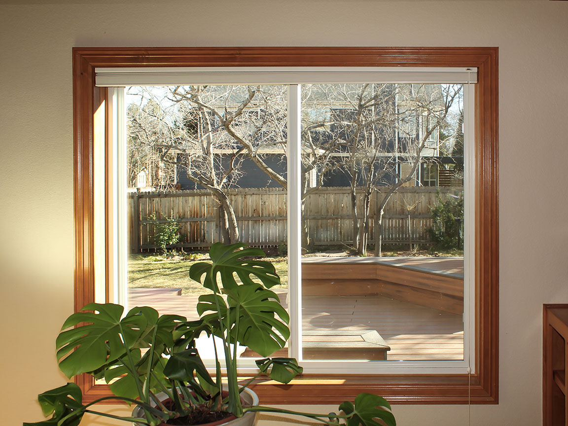 Interior view of sliding patio door opening to backyard deck with natural light.