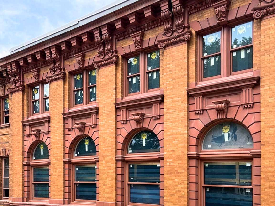 Historic brick building with arched windows and decorative stone details.