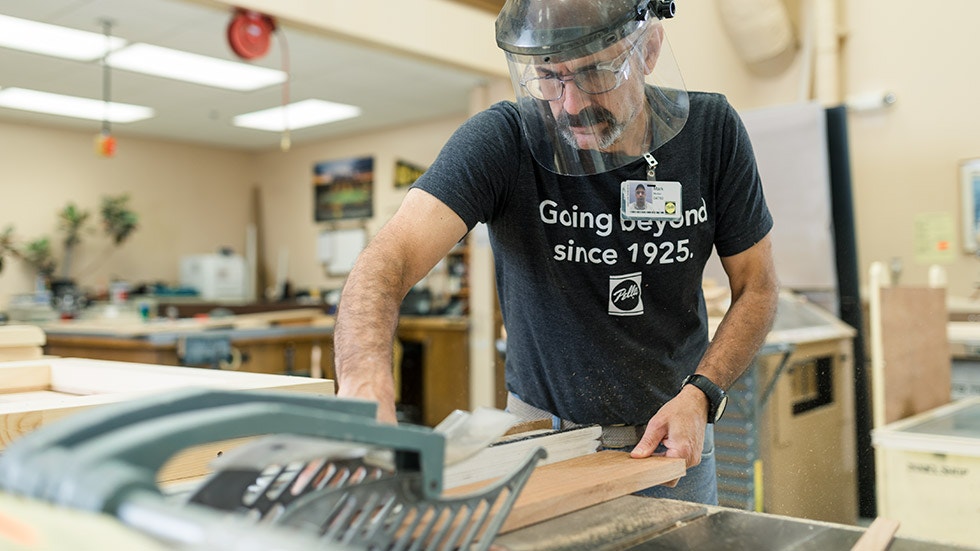 man wearing safety gear working on wood for a pella product