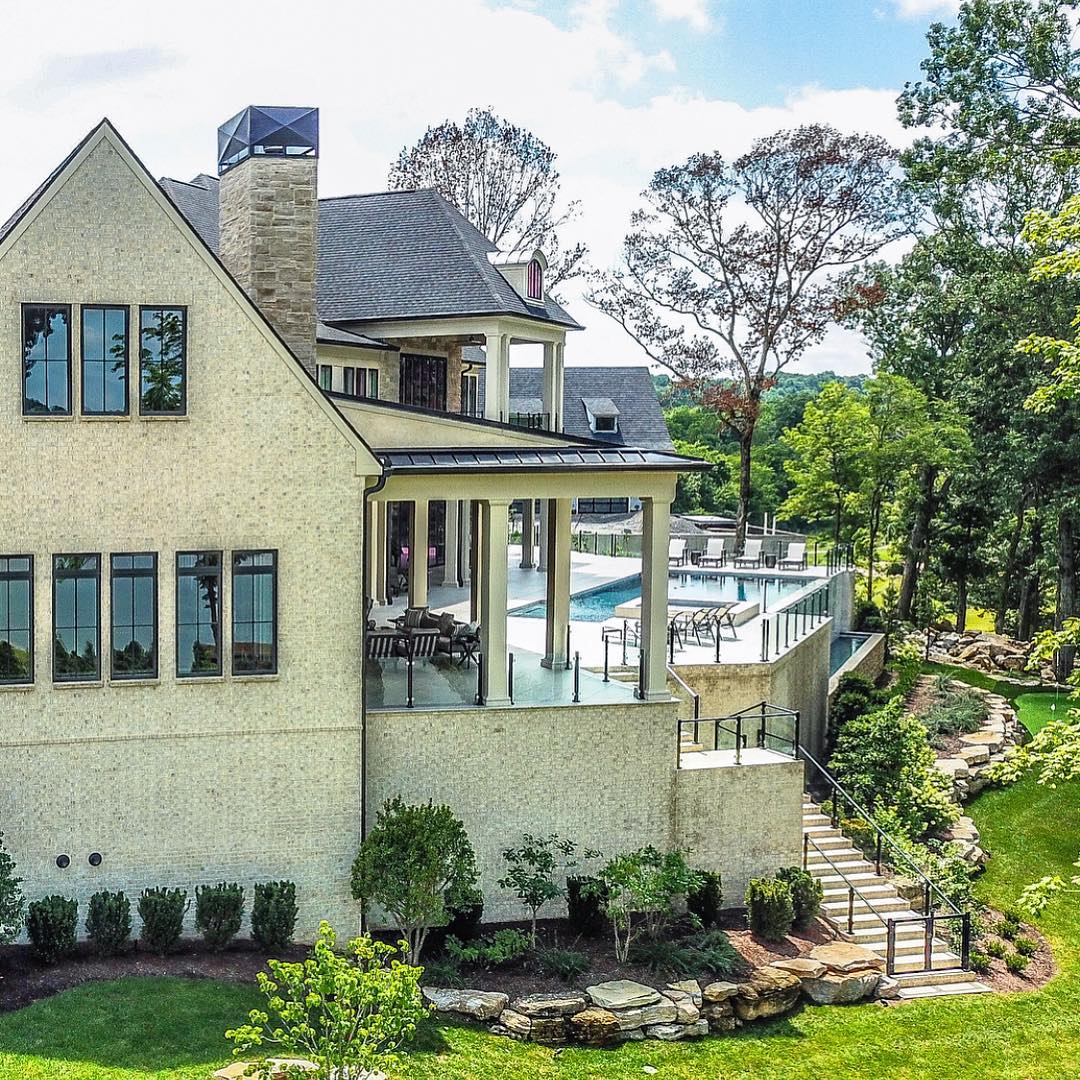 Black Windows Add Modern Touch To Traditional Brick Home Black frame windows line up the side of traditional brick house