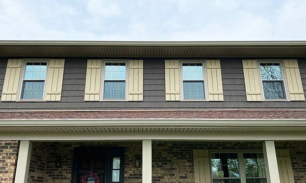 Exterior close up view of newly installed tan Pella 250 Series Windows for Okeana home.