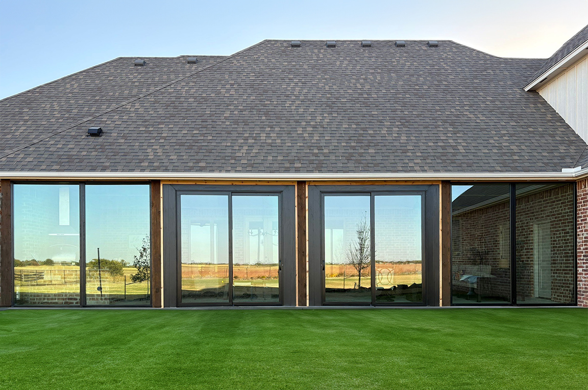 After image of an enclosed patio space with black windows and doors. 
