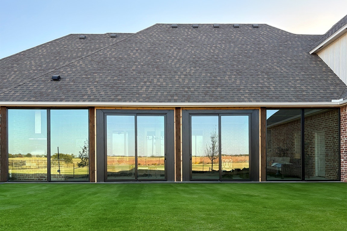 After image of an enclosed patio space with black windows and doors.