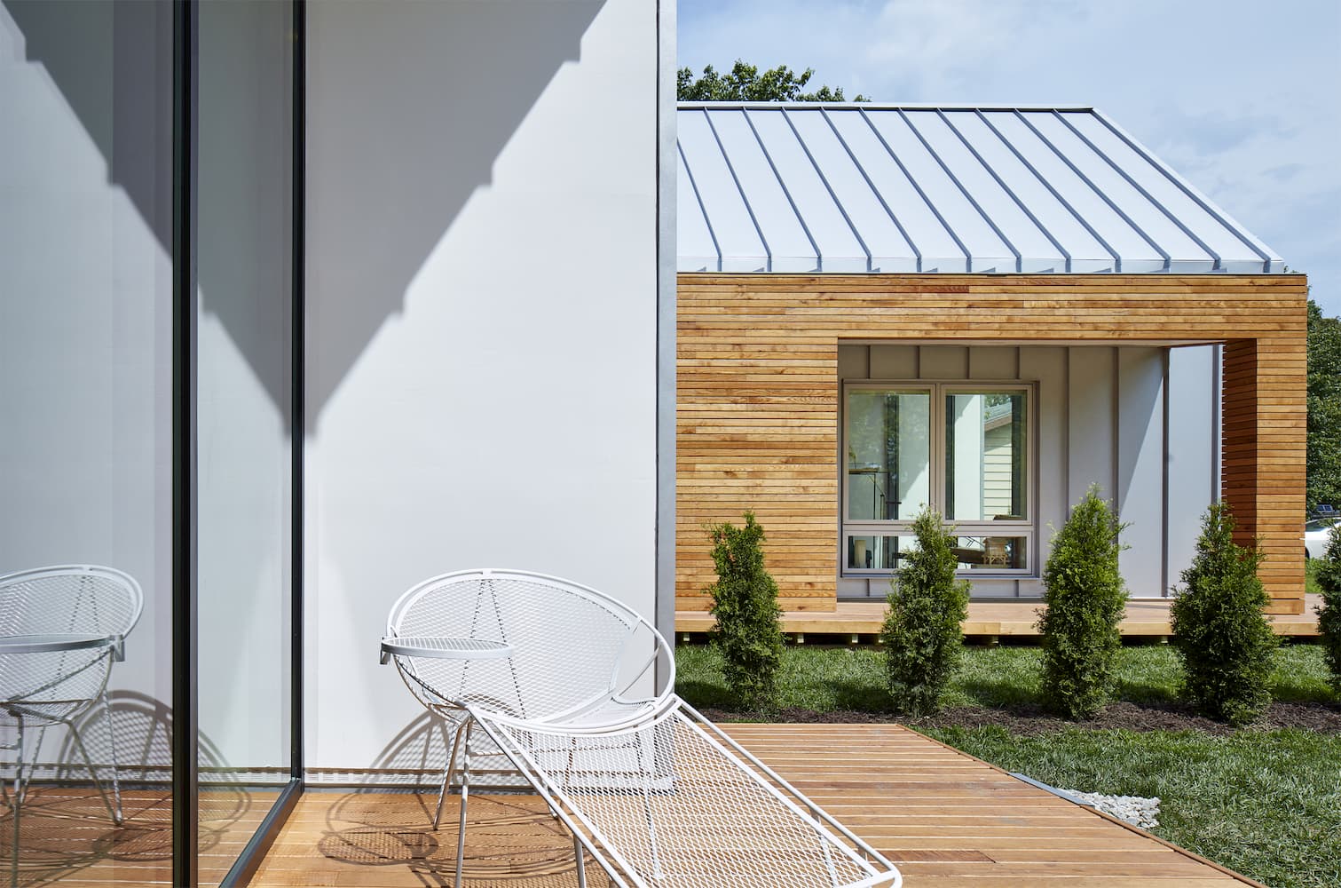 contemporary Patio on modern home has a chair alongside large white picture window
