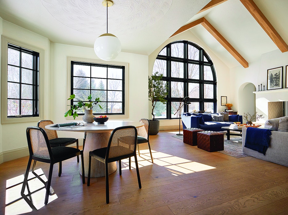 Open breakfast nook and living room with black trim windows.