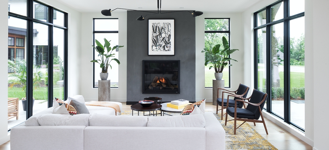 white modern living room surrounded by wood windows