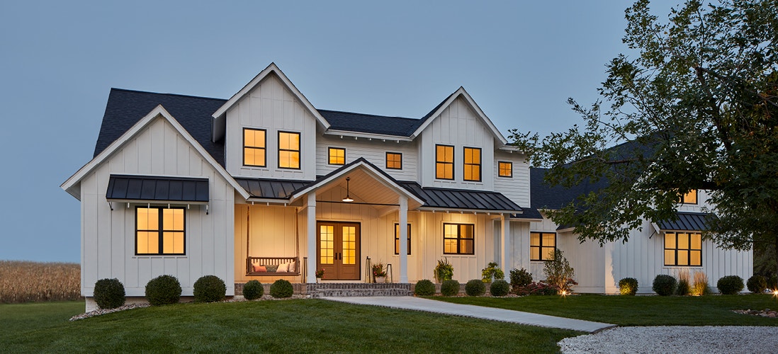 a home exterior at dusk with impervia double-hung windows
