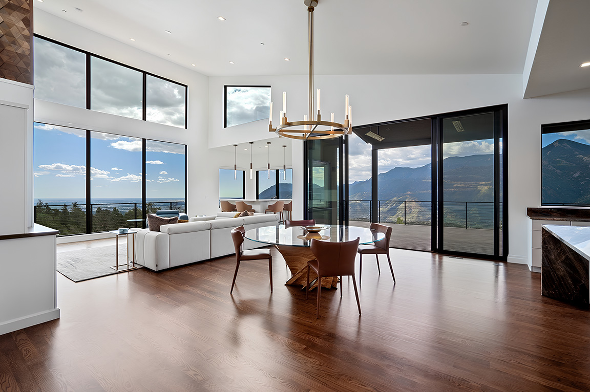 A modern living room with trapezoid windows offering a stunning mountain view.