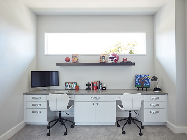 dormer window above a dual desk that spans from wall to wall