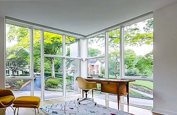 Home office with two walls of glass made from a combination of white fixed windows