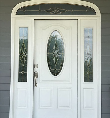 Before white traditional door with sidelights and decorative glass