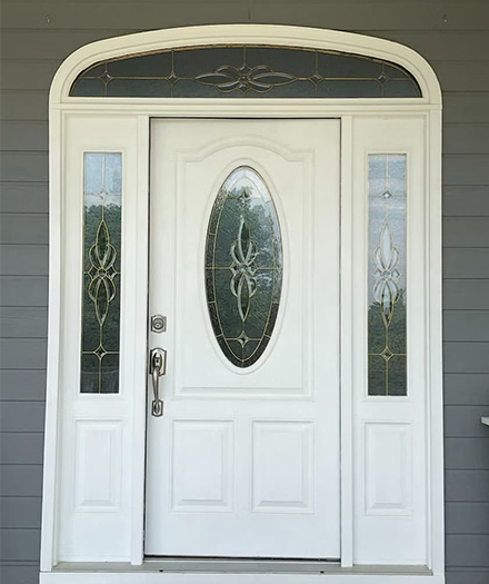 Before white traditional door with sidelights and decorative glass