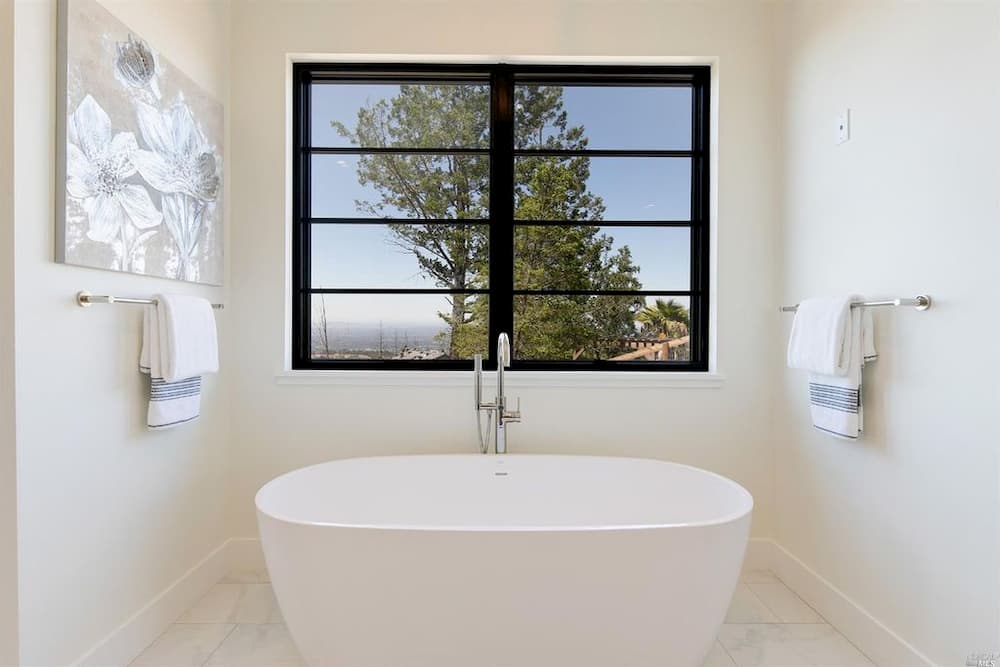 Black windows with horizontal grilles contrast against white bathroom