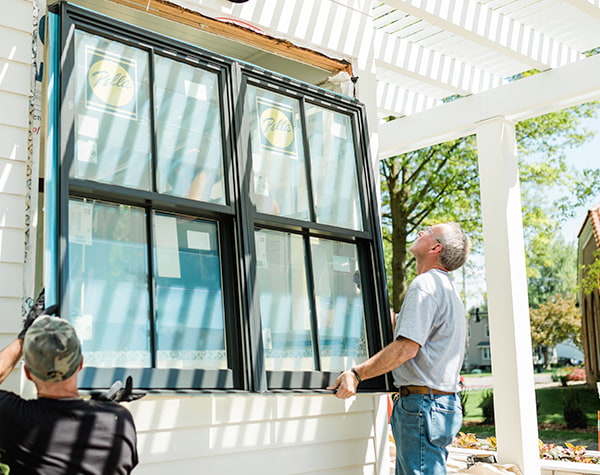 two Pella contractors are installing a two-wide set of double-hung windows