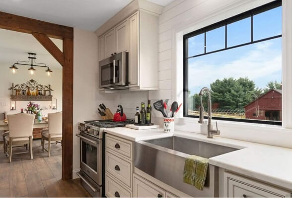 Farmhouse style kitchen with black picture window over the sink