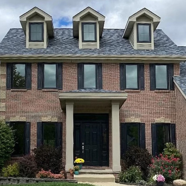 A colonial brick home with new fiberglass Pella Impervia windows.