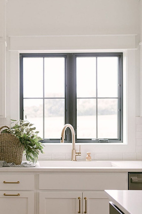 two black casement windows in a modern kitchen with white cabinets