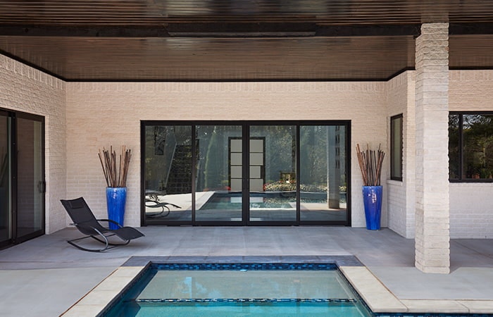 Four-panel french sliding patio door behind a pool 