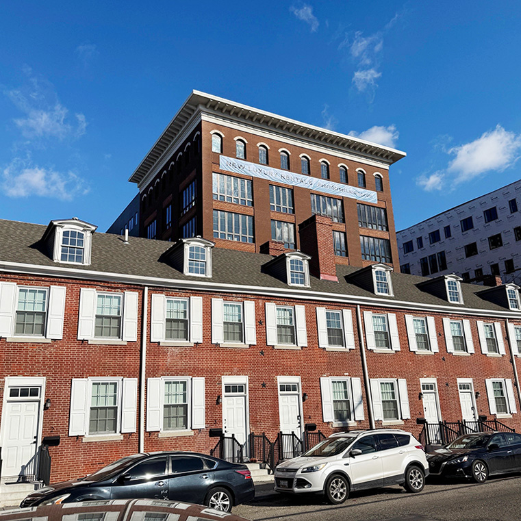 A brick building with vinyl windows and modern architecture, featuring a clear blue sky.