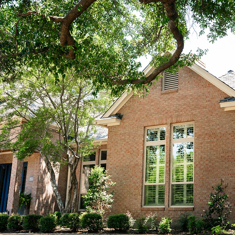 A brick exterior home with front facing, large tan windows in Austin. 