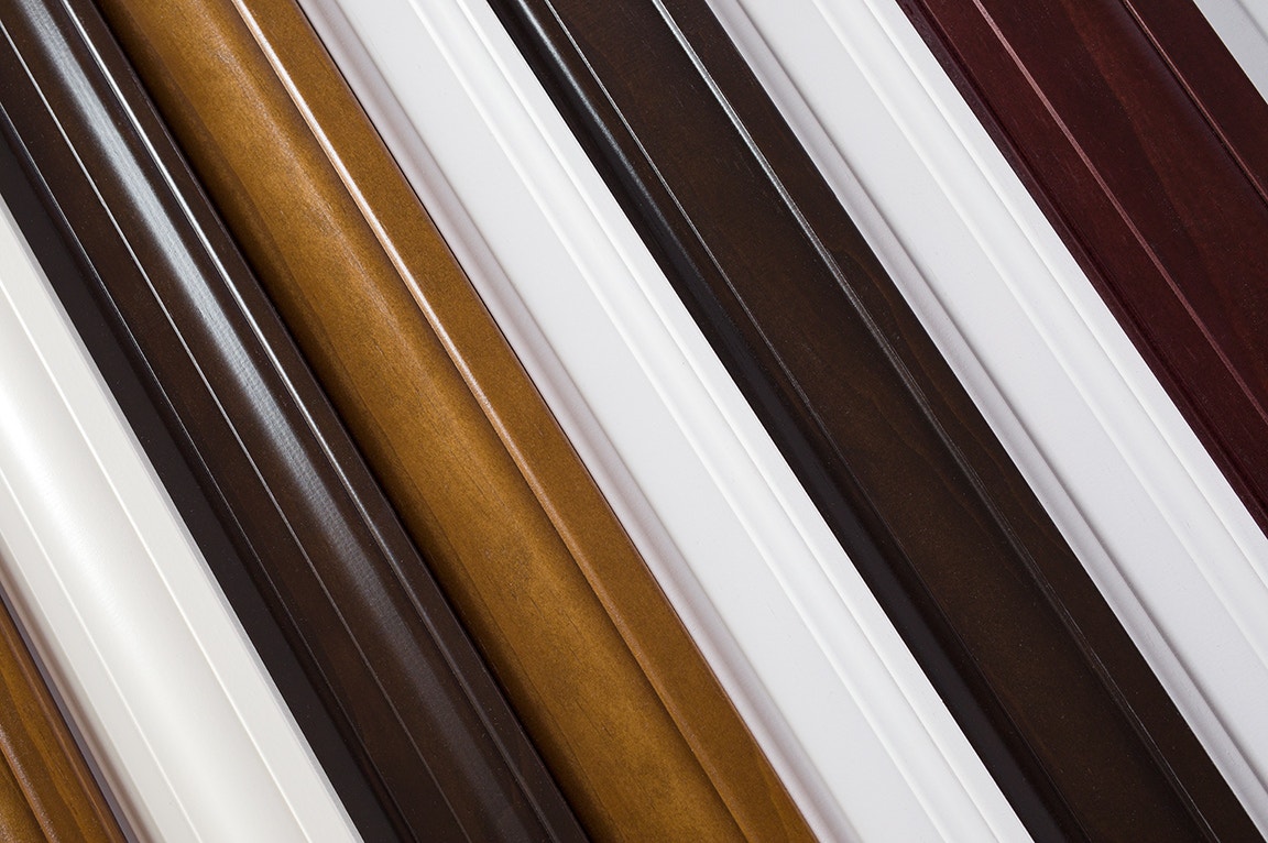 A collection of interior window trim samples in various colors and wood materials.