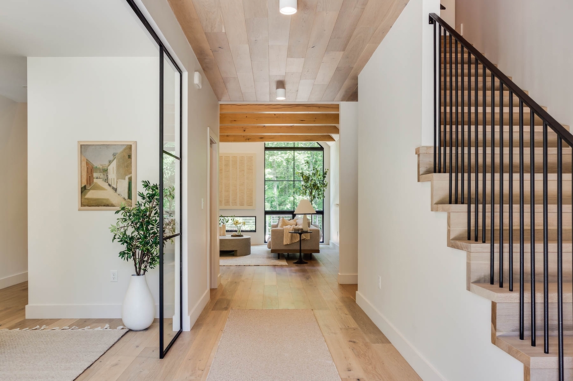 Inside view of hallway with floor-to-ceiling black window at the end.