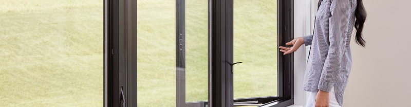 woman in striped shirt using an easy slide operator on a casement window
