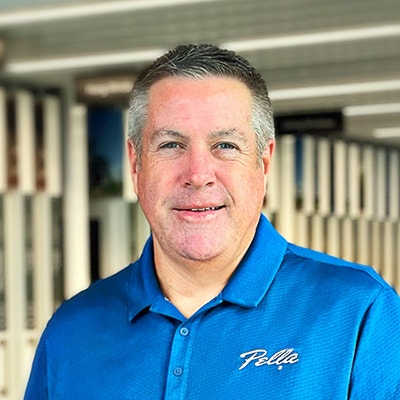 A male with graying hair and a blue shirt is looking at the camera.