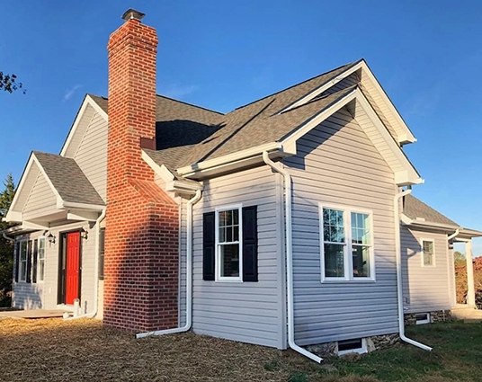 Image of a ranch-style Stewartstown home after renovations and newly installed Pella 250 Series Double-Hung Windows.