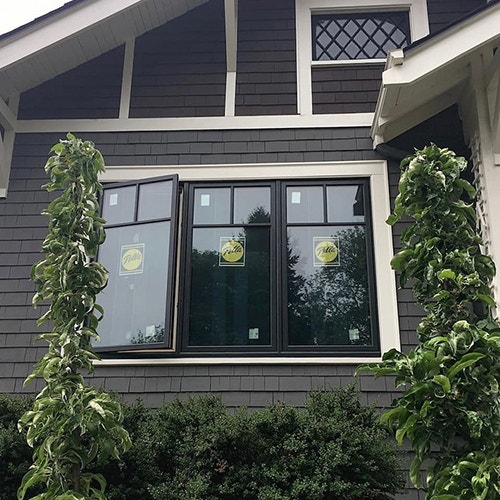 three fiberglass casement windows with Pella stickers on each