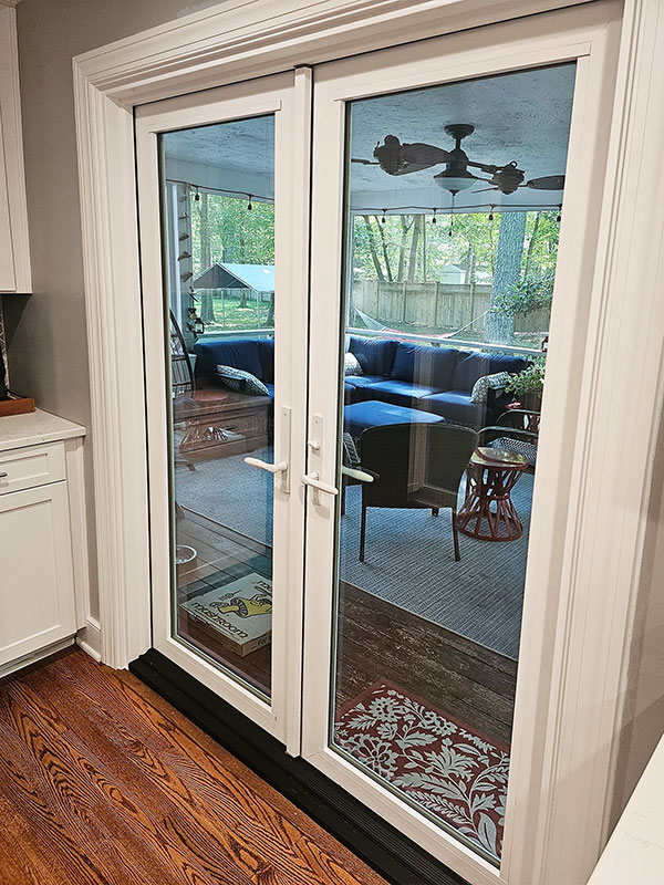 Interior view of white vinyl French doors leading to a Midlothian home patio. 