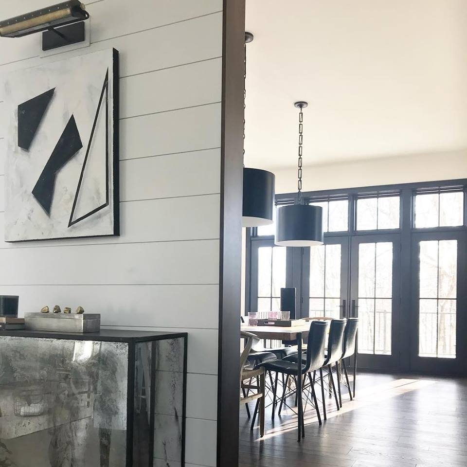 black and white contemporary dining room with a wall of black french doors